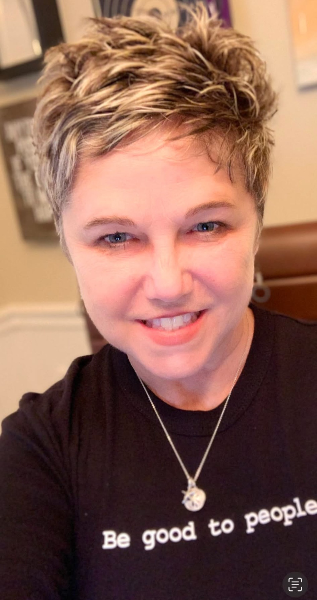 Caroline smiling, wearing a 'Be good to people' shirt